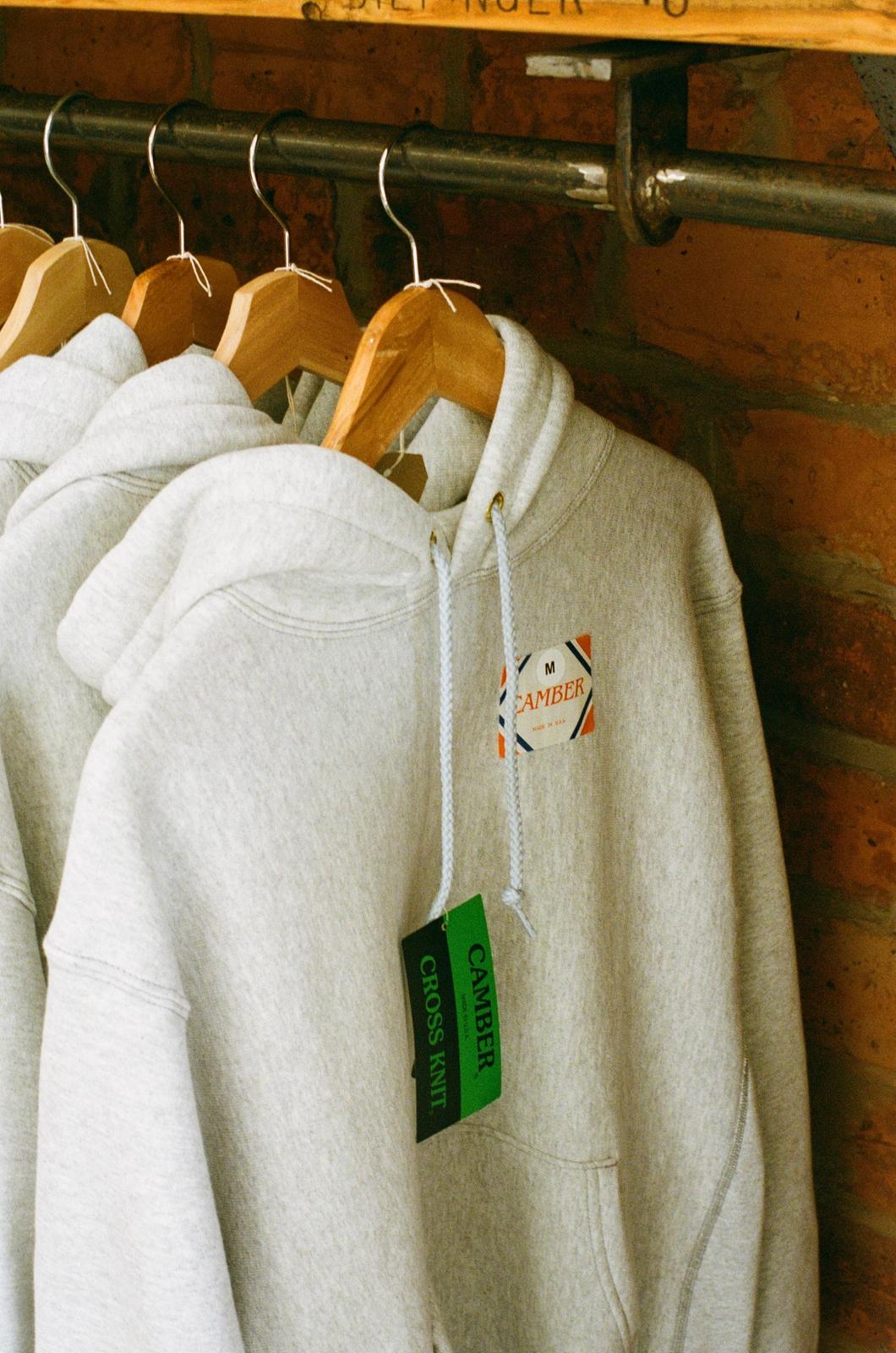 camber grey hoodies hanging on rail in orzel store