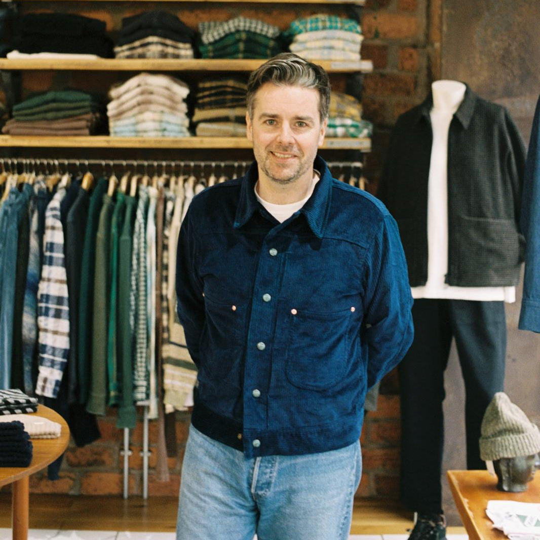 Grant, store owner, standing inside the shop wearing Wythe New York jacket