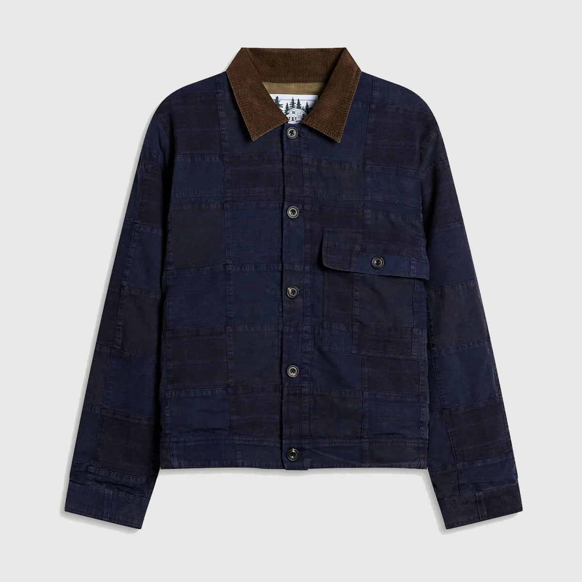 A dark navy blue patchwork canvas jacket with a brown corduroy collar, featuring a button-up front and a chest pocket, displayed on a light gray background.