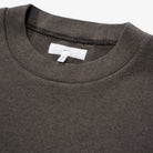 Close-up of a dark t-shirt with a brand label on a white background
